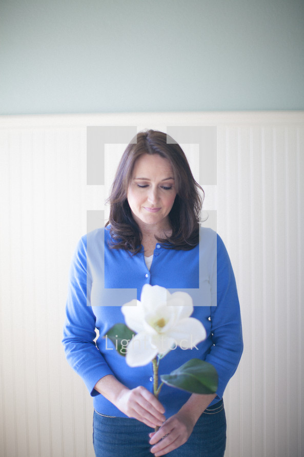 woman holding a magnolia flower in prayer