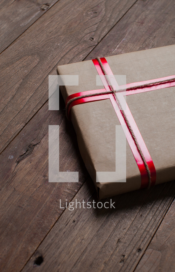 wrapped gift in brown paper and red ribbon 