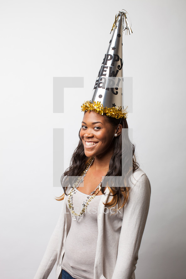 A woman wearing a New Year's party hat. 