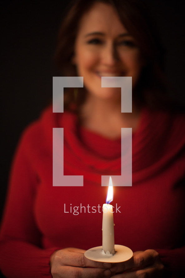 woman at a Christmas eve candle light service 