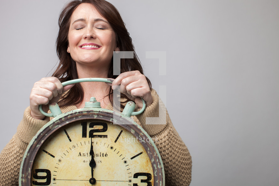woman holding a clock at midnight
