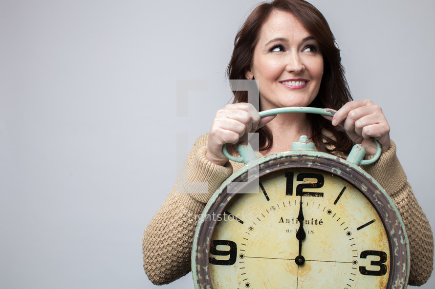woman holding a clock at midnight