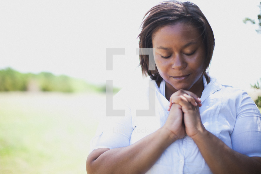 Woman praying outside.