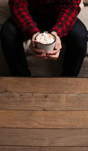 a man holding a mug of hot cocoa 