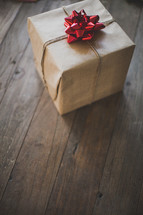 gift wrapped in brown paper and a red bow 