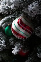 ornaments hanging on a flocked Christmas tree 