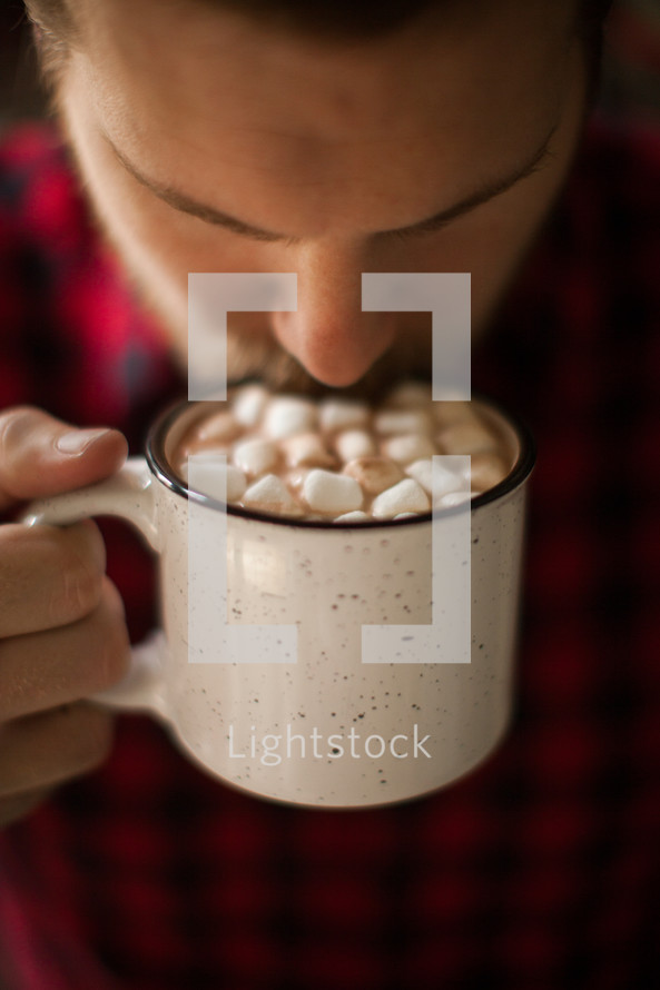 a man drinking a mug of hot chocolate 