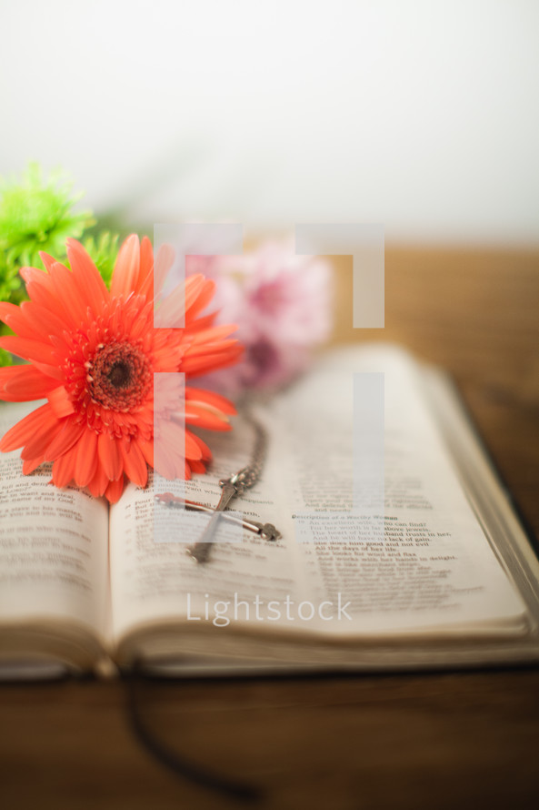 Flowers and a cross on an open Bible.