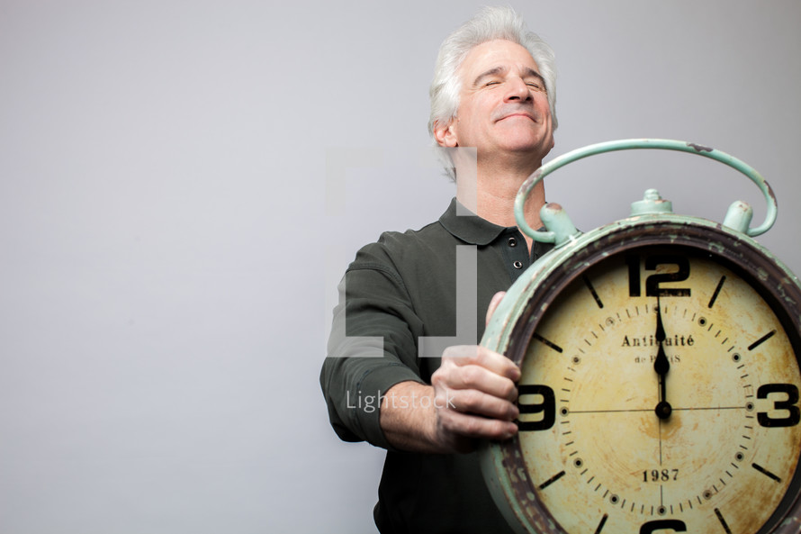 man holding a clock at midnight