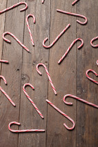 candy canes spread out of a wood floor 