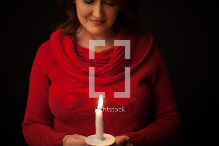 woman at a Christmas eve candle light service 