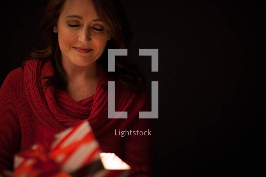 Opening a gift box - An illuminated gift - the gift of salvation through Jesus Christ 