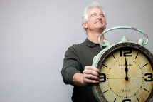 man holding a clock at midnight
