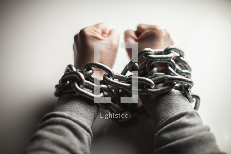 Wrists bound with chain.