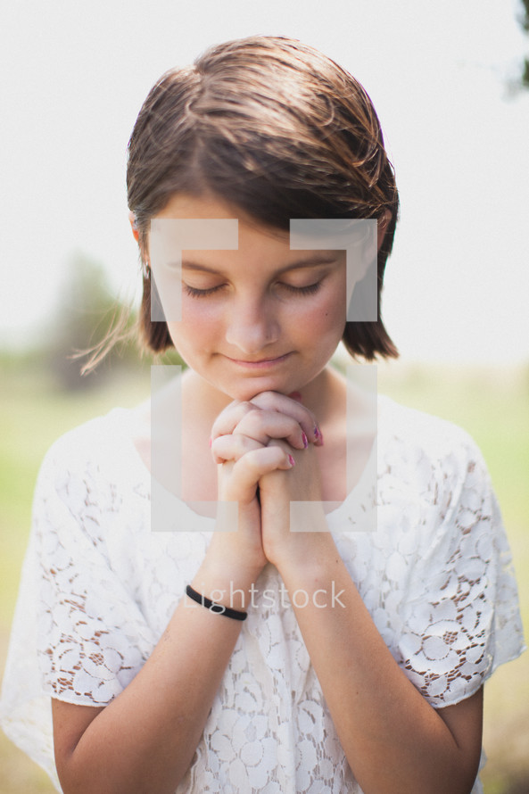 young girl with praying hands 