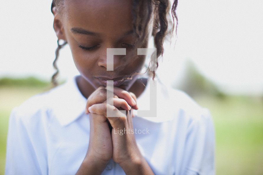 Girl praying outside.