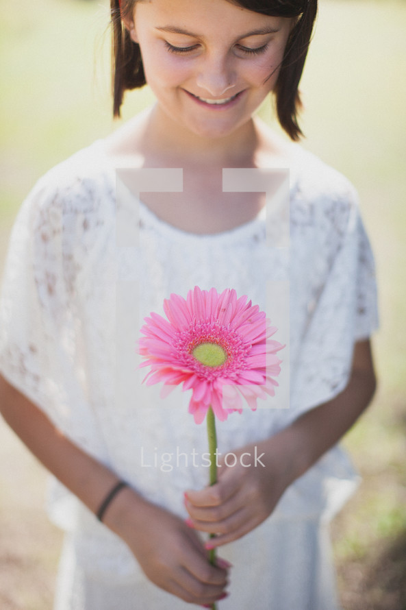 young girl holding a gerber daisy 