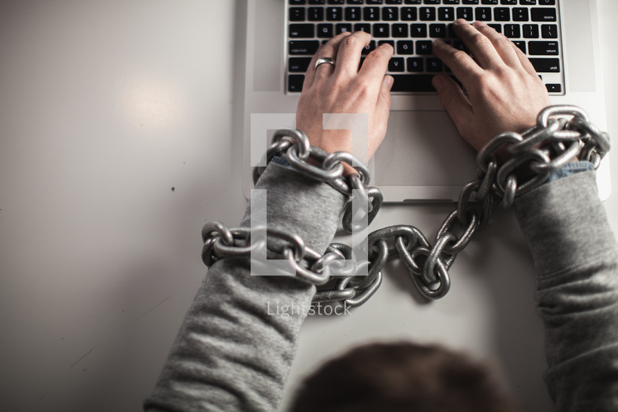 man bound in chains on laptop computer 