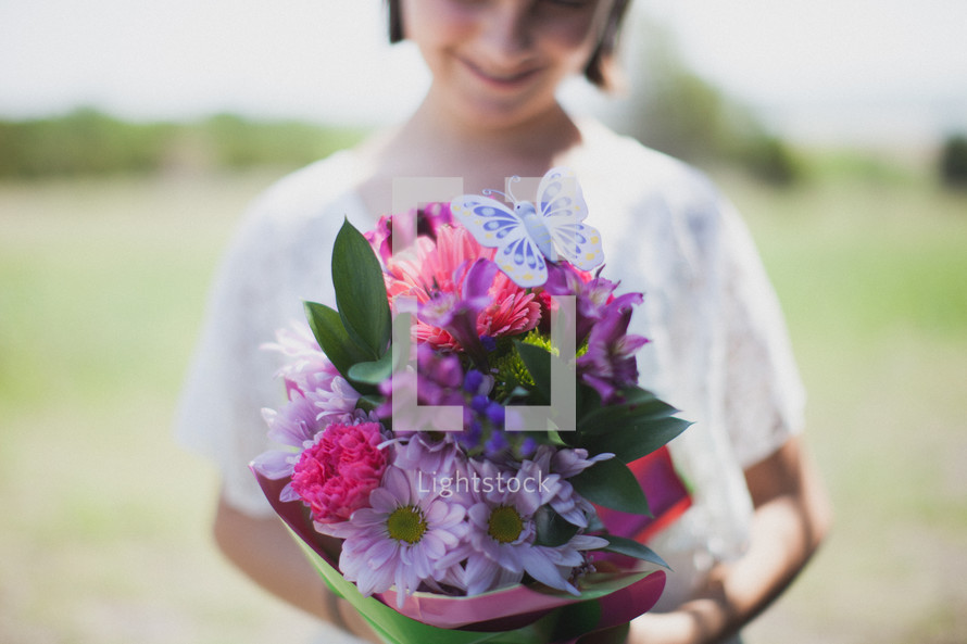 Girl holding a bouquet of flowers.