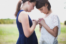 young girls praying together 