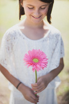 young girl holding a gerber daisy 