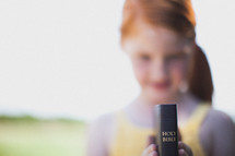 young girl holding a Bible 
