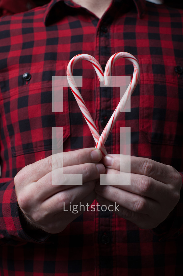 man holding candy canes in the shape of a heart 