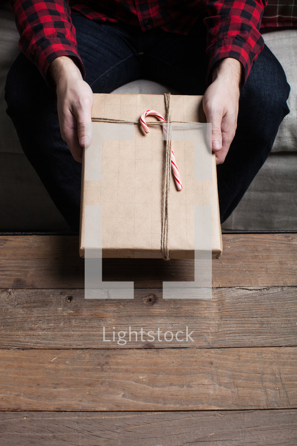 a man holding a wrapped Christmas gift 
