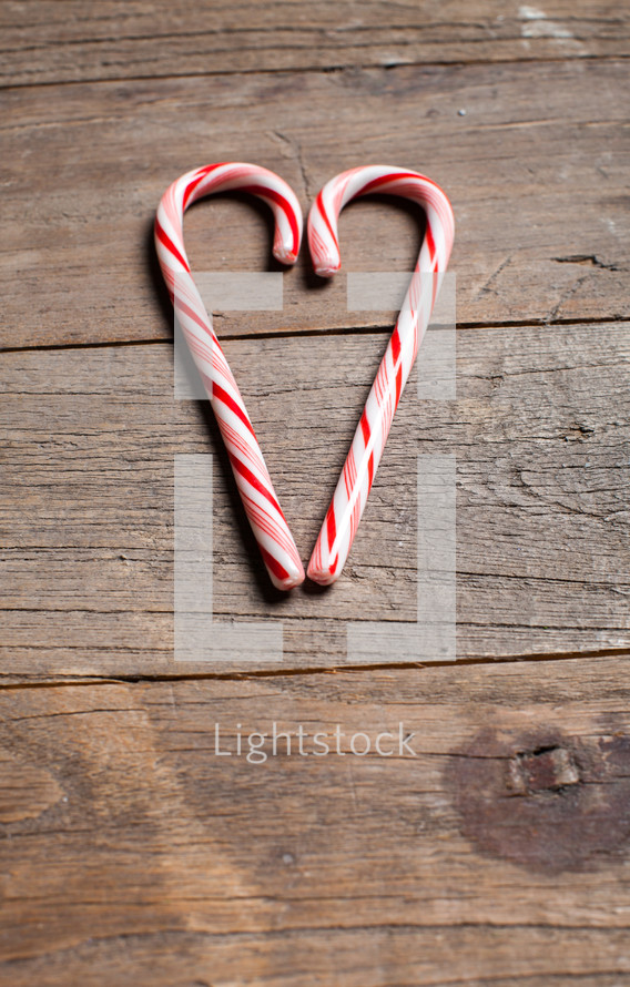 candy canes in the shape of a heart on a wood floor 