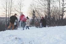 A group of young people having a snowball fight.