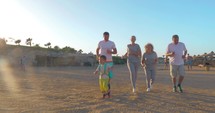 Sportive family running on the beach