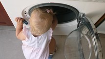 Little child exploring the washing machine