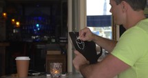 Man in cafe drawing coffee list with chalk