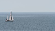 Yacht with sails in quiet blue sea