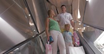 Family riding down on escalator in shopping mall