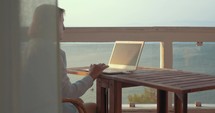 Woman browsing on laptop using mobile internet
