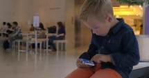 Kid with mobile phone in shopping mall