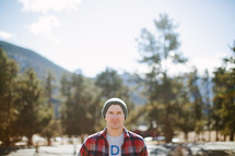 man in a plaid shirt standing outdoors