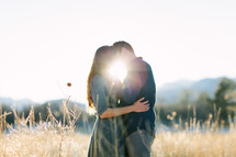 couple hugging outdoors and a sunburst 