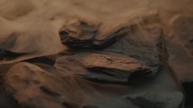 Rough abstract wet stones rotating with a foggy atmosphere around them 