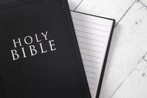 Bible and notebook on a white wood background 