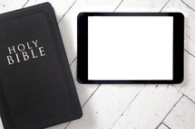 Bible and tablet on a white wood background 