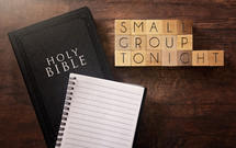 Bible and notebook on a wood background - small group tonight 