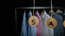 Sale tags with clothes in the background 