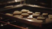 Heart shaped cookies being moved on a tray for Valentine's Day