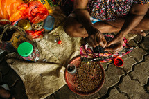 a woman sewing on beads 
