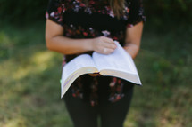 torso of a teen girl reading a Bible 