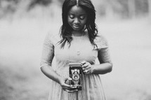 woman holding an antique camera 