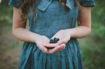 girl with hand full of blackberries 