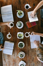 young women sitting around a table reading Bibles 
